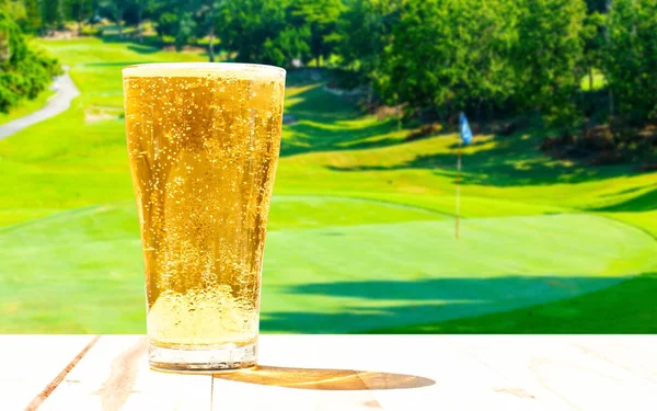 Glass of beer on the background blur of golf.