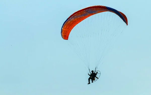 青い空に対するカラフルな動力パラグライダー — ストック写真