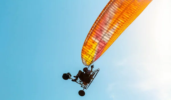 青い空に対するカラフルな動力パラグライダー — ストック写真