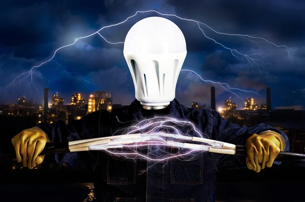 Electricista con una bombilla en lugar de una cabeza en el fondo del paisaje industrial y el cielo con un rayo —  Fotos de Stock