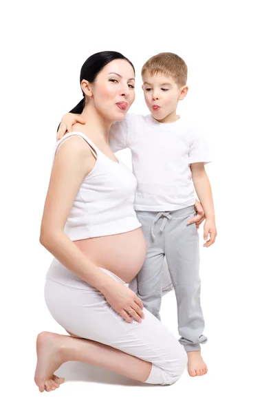 Beautiful young pregnant woman with son showing tongue — Stock Photo, Image