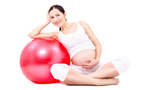 Красивая беременная женщина, сидящая с фитболом — стоковое фото