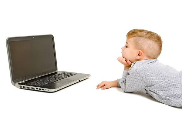 Boy looking at laptop lying on the floor — Stock Photo, Image