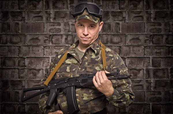 Soldado no fundo da parede de tijolo — Fotografia de Stock