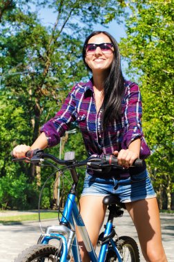 Bir bisiklet üzerinde gülümseyen güzel kadın