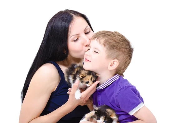 Loving mother kisses son, holding two tricolor kittens — Stock Photo, Image