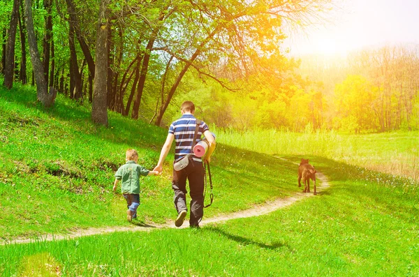 Fadern, sonen och hunden på en promenad i skogen — Stockfoto