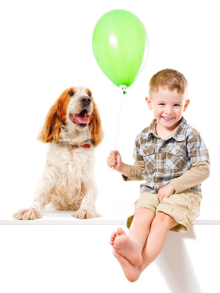 Happy boy and Russian Spaniel playing with a balloon