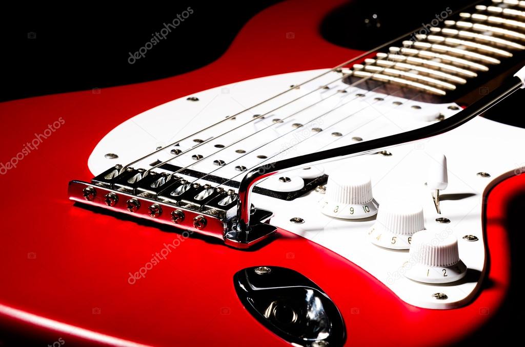 The electric guitar, closeup on a black background