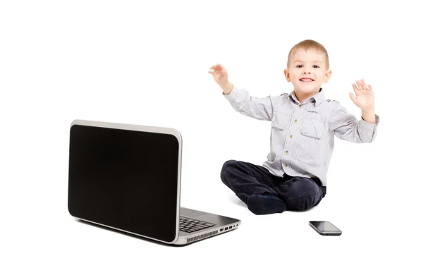 Menino alegre sentado diante de um laptop — Fotografia de Stock