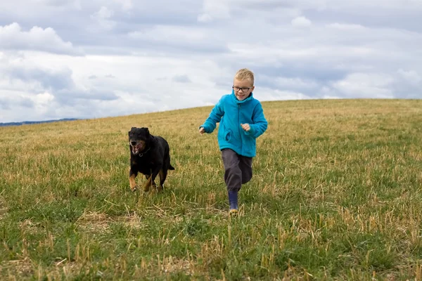 Хлопчик біжить з собакою — стокове фото