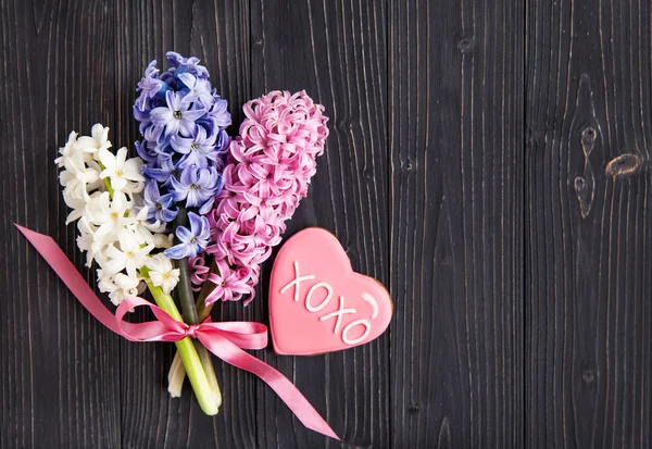 Fresh  hyacinths and biscuits in the shape of a heart — Stock Photo, Image
