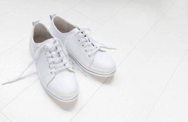 Beyaz arka planda beyaz deri bir çift spor ayakkabı. Boşluğu kopyala