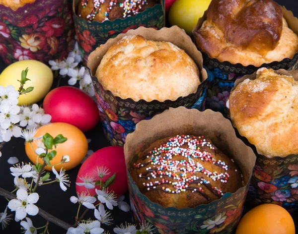 Påsk söta bröd med färgglada ägg och körsbär grenar — Stockfoto