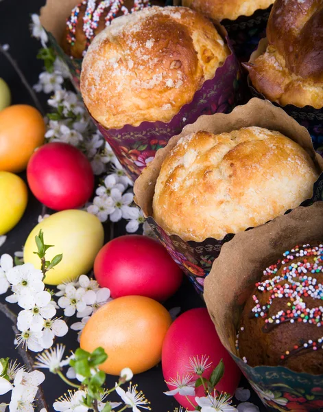 Påsk söta bröd med färgglada ägg och körsbär grenar — Stockfoto