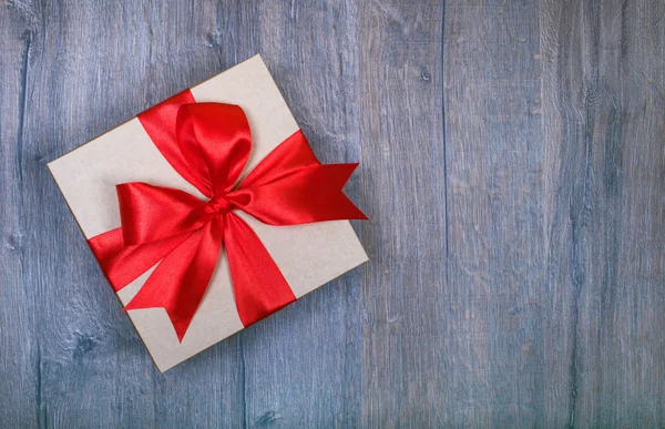 Gift box with bow on wooden background — Stock Photo, Image