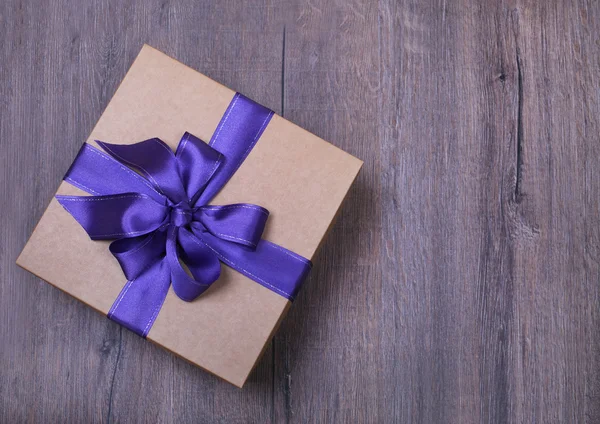 Caja de regalo con lazo sobre fondo de madera —  Fotos de Stock