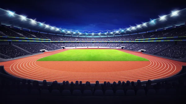 Estádio de atletismo com pista e campo de grama na frente à noite vista — Fotografia de Stock