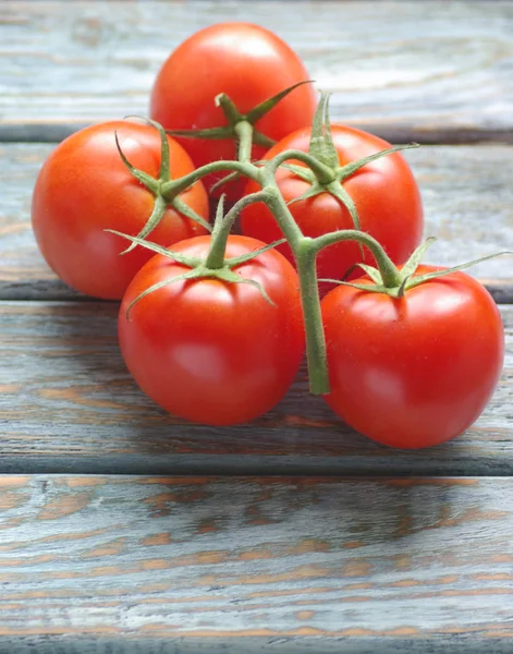 Tomates sobre fondo rústico de madera Imagen de stock