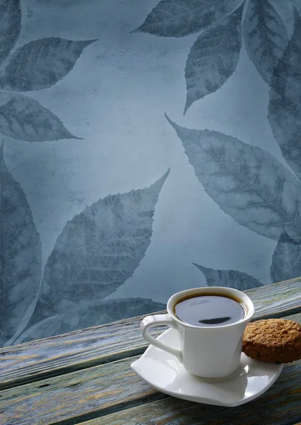 Tasse Kaffee mit blauen Blättern Hintergrund — Stockfoto