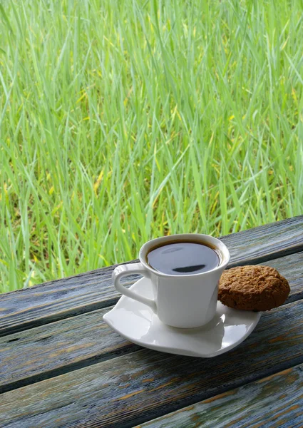 Cup of coffee with green grass background — Stock Photo, Image