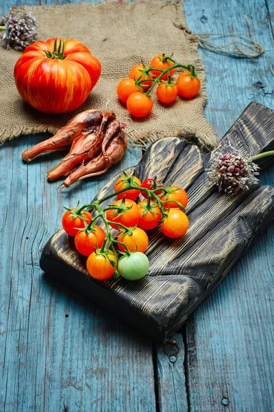 Branch of tomatoes on the kitchen board — Stock Photo, Image