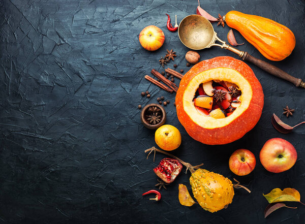 Autumn alcoholic drink mulled wine in pumpkin.