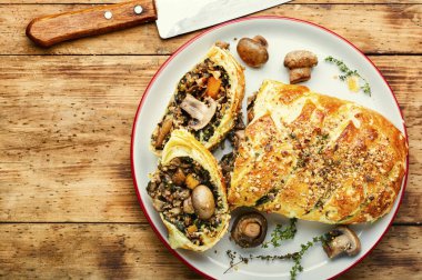 Lezzetli mantarlı turta veya eski ahşap masada Wellington mantarı. İngiliz yemeği.