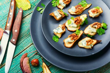 Kuru armut, mavi peynir ve ahşap masada ceviz çerezi.