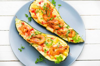 Domates, karides, peynir ve otlarla pişirilmiş kabak yarımları..