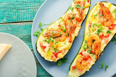 Domates, karides, peynir ve otlarla pişirilmiş kabak yarımları..