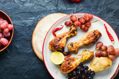 Üzümlü fırında tavuk budu. Tabakta kızarmış tavuk budu.