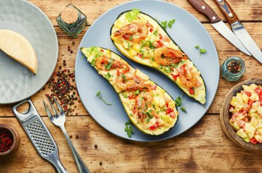 Domates, karides, peynir ve otlarla pişirilmiş kabak yarımları..