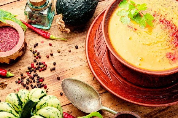 Kırsal ahşap masada bir kase kabak çorbası.