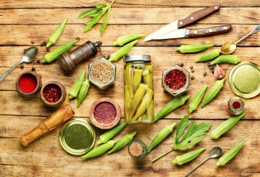 Ev yapımı sonbahar sebze koruyucusu. Tahta masa üzerinde turşulu bamya.