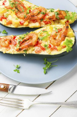 Domates, karides, peynir ve otlarla pişirilmiş kabak yarımları..