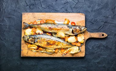 Elmayla pişirilmiş lezzetli uskumru balığı, mutfak tahtasında servis edilir..