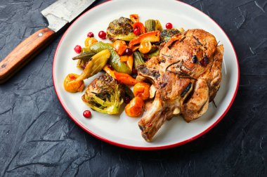 Tabakta ızgara domuz eti. Farklı sebzelerle fırında et.