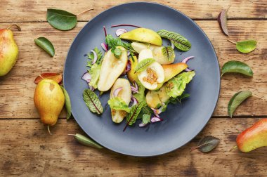 Armut ve ahşap masadaki bitkilerle iştah açıcı salata.