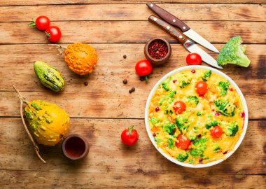 Brokolili sebze güveci, domates ve balkabağı eski ahşap masada. Frittata.