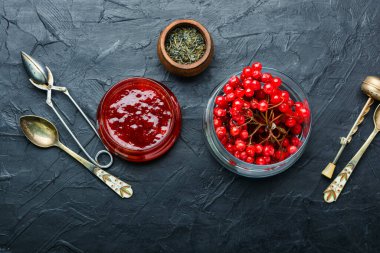 Reçelli cam kavanoz ve taze viburnum üzümü.