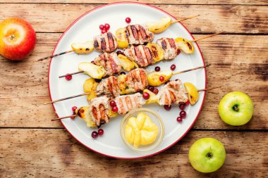 Barbekü hindi şiş kebap ve kırsal ahşap masa üzerinde elma.