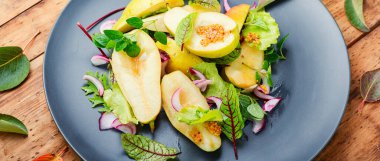 Armut ve ahşap masadaki bitkilerle iştah açıcı salata.