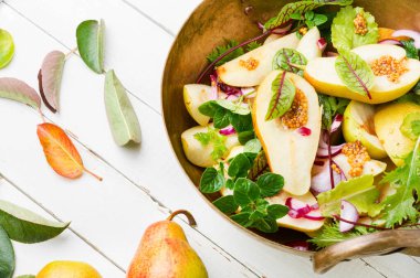 Armut, ot ve hardallı sonbahar salatası. Yeşil yapraklar ve armutlardan yapılmış sağlıklı salata.