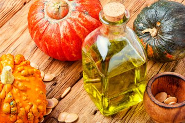 Kabak yağı ve çiğ balkabağı. Bir kase kabak tohumu yağı.