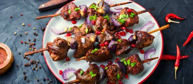 Ahşap şişte soğanlı ızgara ciğer kebabı.