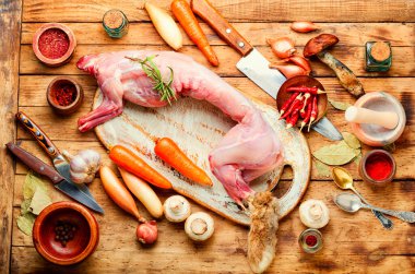 Baharatlı çiğ tavşan eti ve ahşap masa.