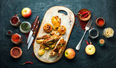 Elmayla pişirilmiş tavuk, mutfak tahtasının üzerinde dilimlenmiş. Baharatlı tavuk.