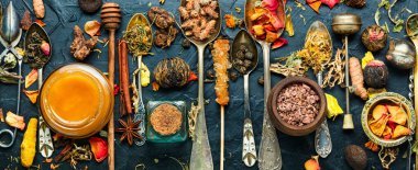 Kurutulmuş şifalı otlar, bitkiler, kuru çay yaprakları, kaşıklarda çeşitli çay çeşitleri. Alternatif bitkisel ilaçlar.