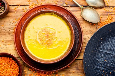 Tahta masada bir tabak vejetaryen kırmızı mercimek çorbası.